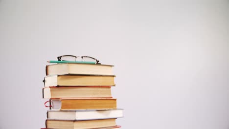 spectacles and pencil on book stack 4k