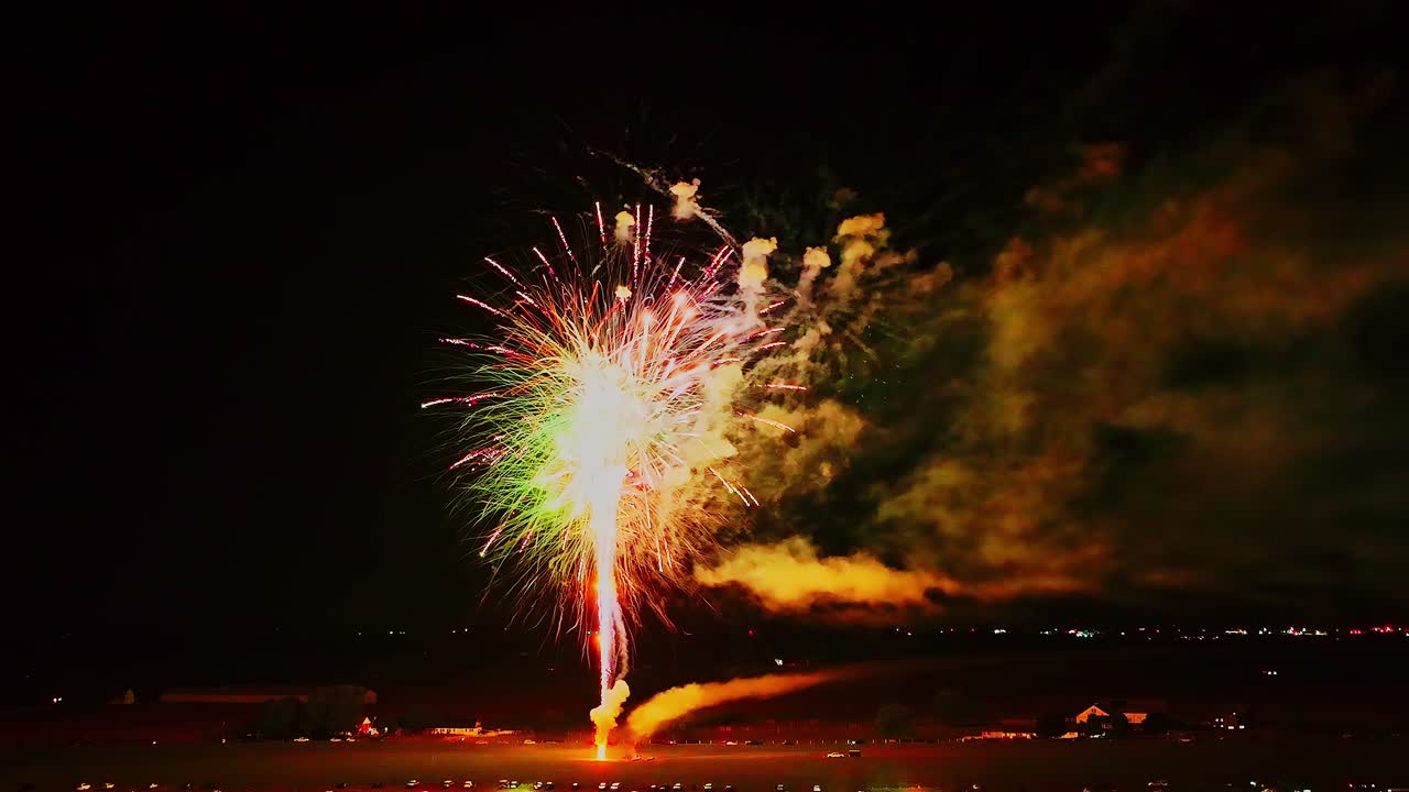 Explosive bursts of colorful fireworks light up the night sky, creating a breathtaking spectacle during a festive evening celebration in an open area.