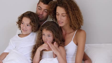 family resting on bed together