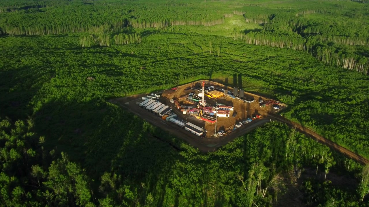 Morning Aerial Flyover of a Drilling Rig in Endless Green Fields of Alberta, Canada