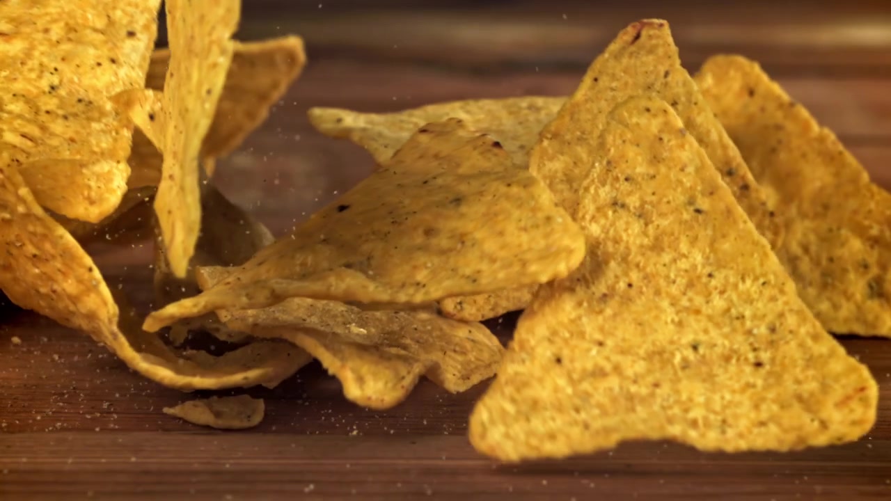 Slow motion när tortillachips faller ner på ett träbord