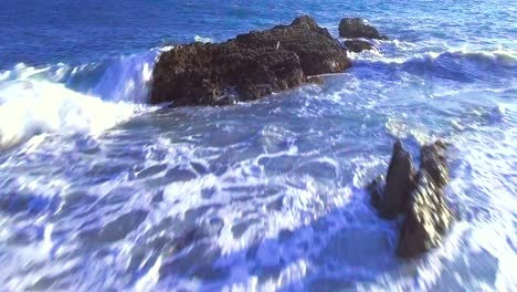 aerial, drone shot of point mugu, moving forward towards rock and ocean, on a sunny day, in santa monica, california, usa