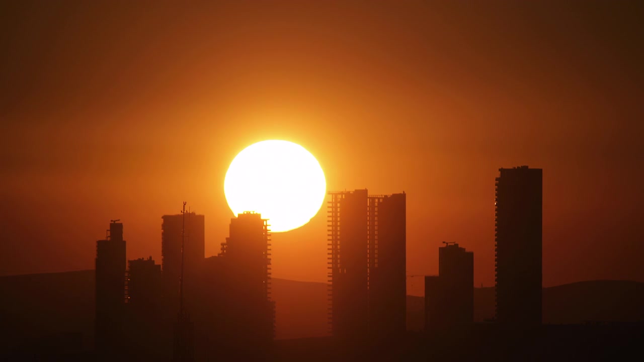 Sol se Pondo Atrás de Arranha-céus de Cidade Moderna