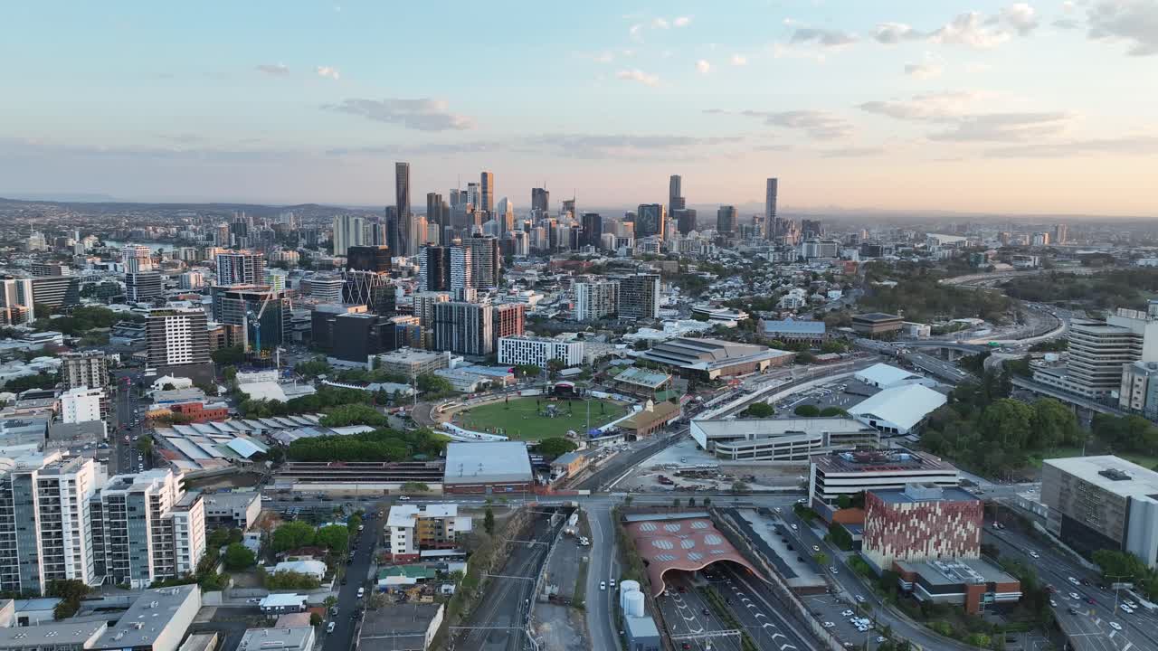 Establishing pull away drone shot of Brisbane City, shot during sunset, flying over the inner city bypass ICB road network