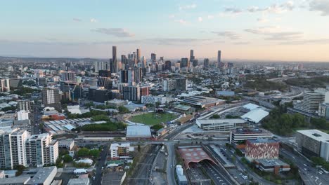Establishing-pull-away-drone-shot-of-Brisbane-City,-shot-during-sunset,-flying-over-the-inner-city-bypass-ICB-road-network
