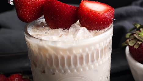 pink cocktail drink with strawberry liqueur, vanilla vodka and cream. party drink with strawberries. fruit cocktail with fresh strawberries as a garnish. cold and refreshing