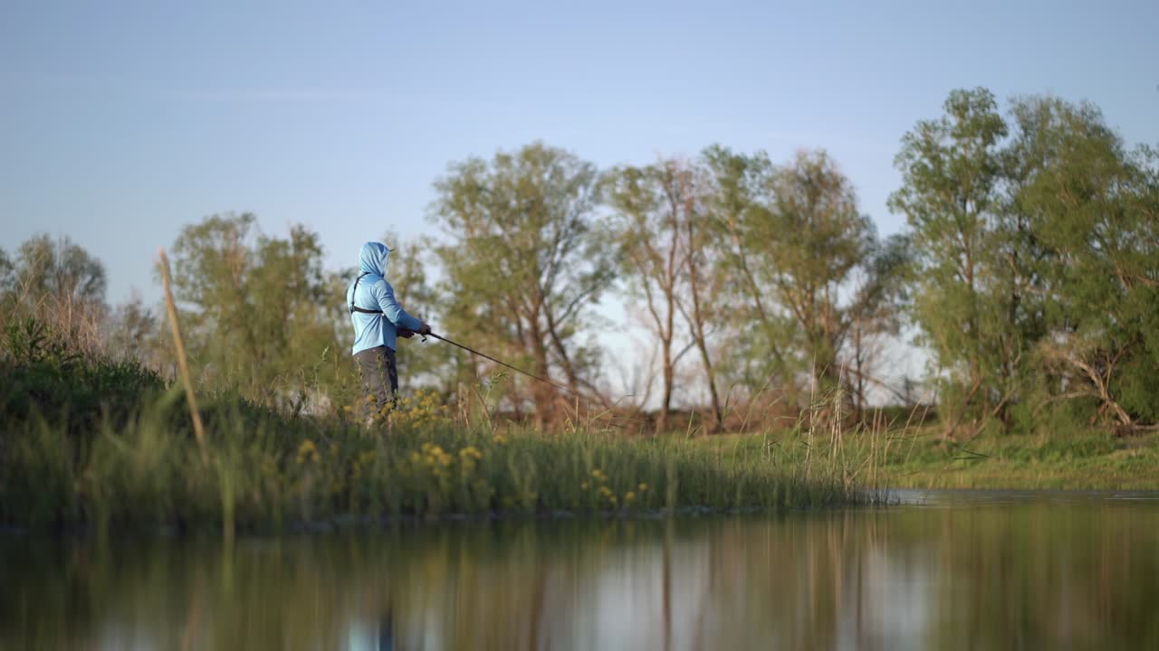 Il pescatore sportivo cattura un pesce predatore a spinning sul lago
