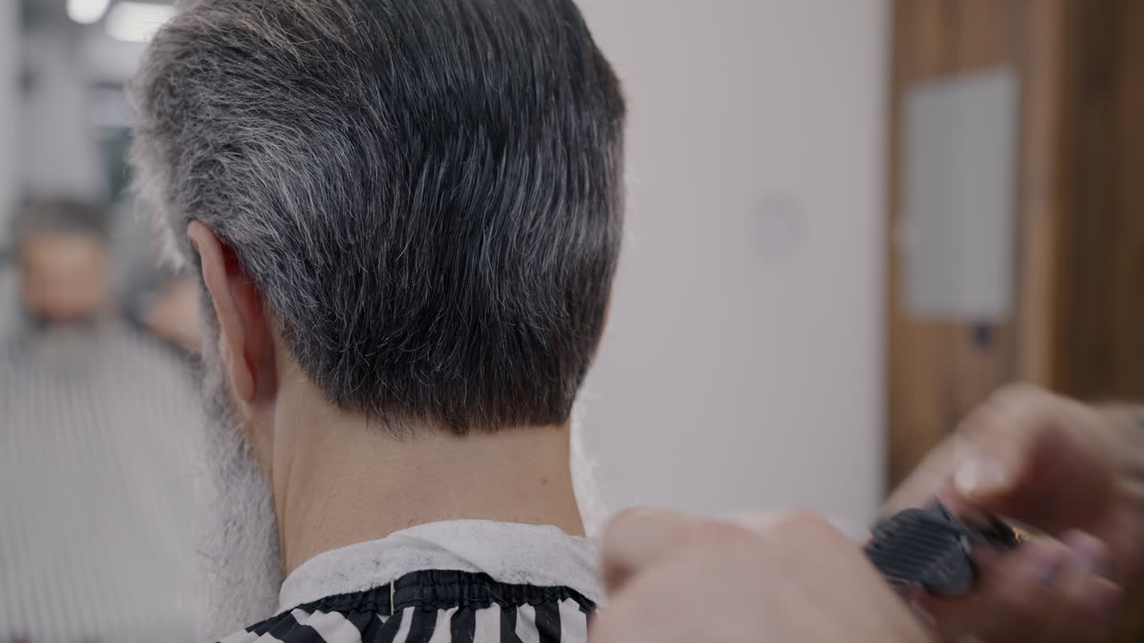 한 남자가 이발장에서 헤어스타일을 하고 있다.