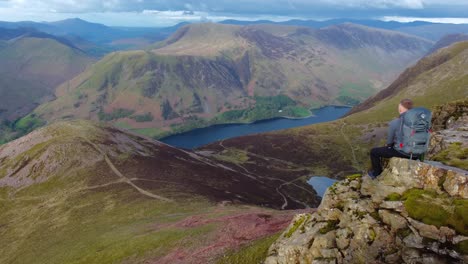 video cinematográfico de un excursionista sentado disfrutando de increíbles vistas desde red pike a través de buttermere en el distrito de los lagos, reino unido