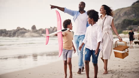 Caminando,-Familia-Feliz-En-La-Playa-Juntos-Para-Hacer-Un-Picnic