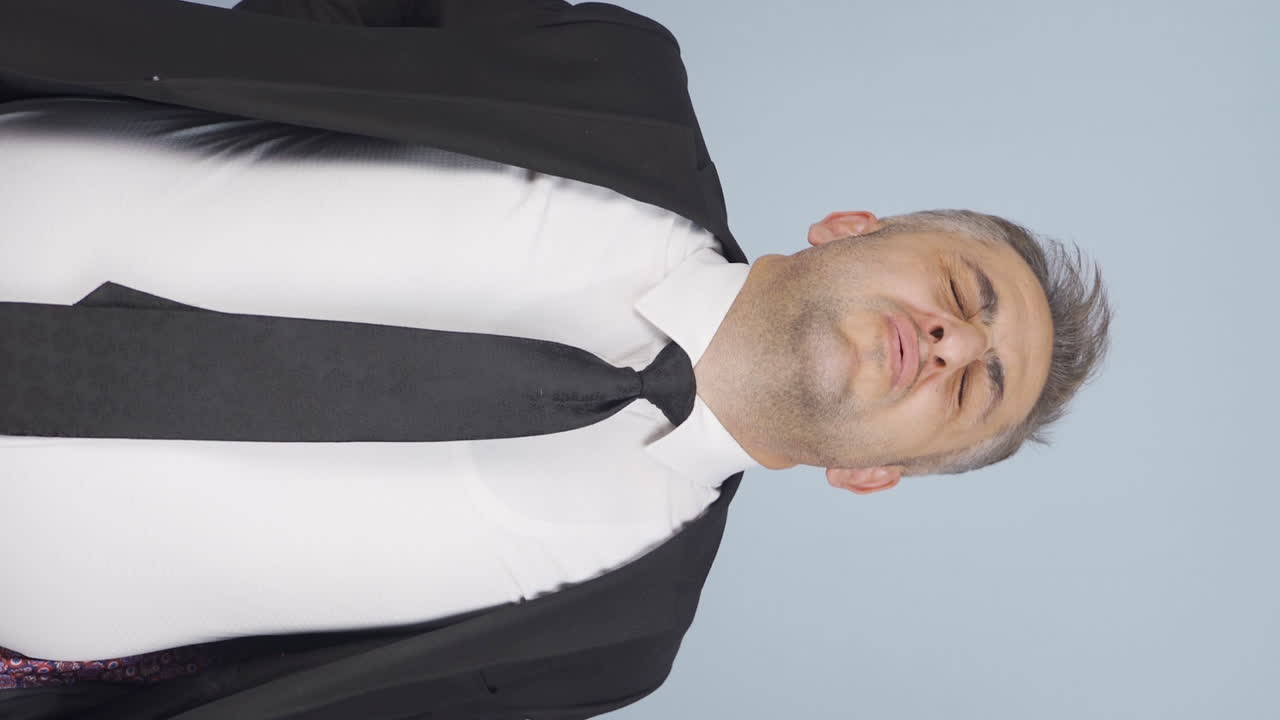 허리 통증을 경험하는 사업가의 수직 비디오.