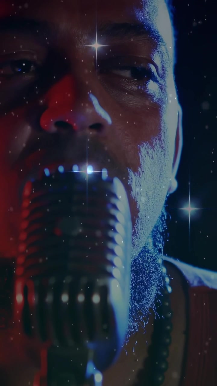 Vertical video: Male singer singing into mic, camera pulling back, stars highlighting face in music