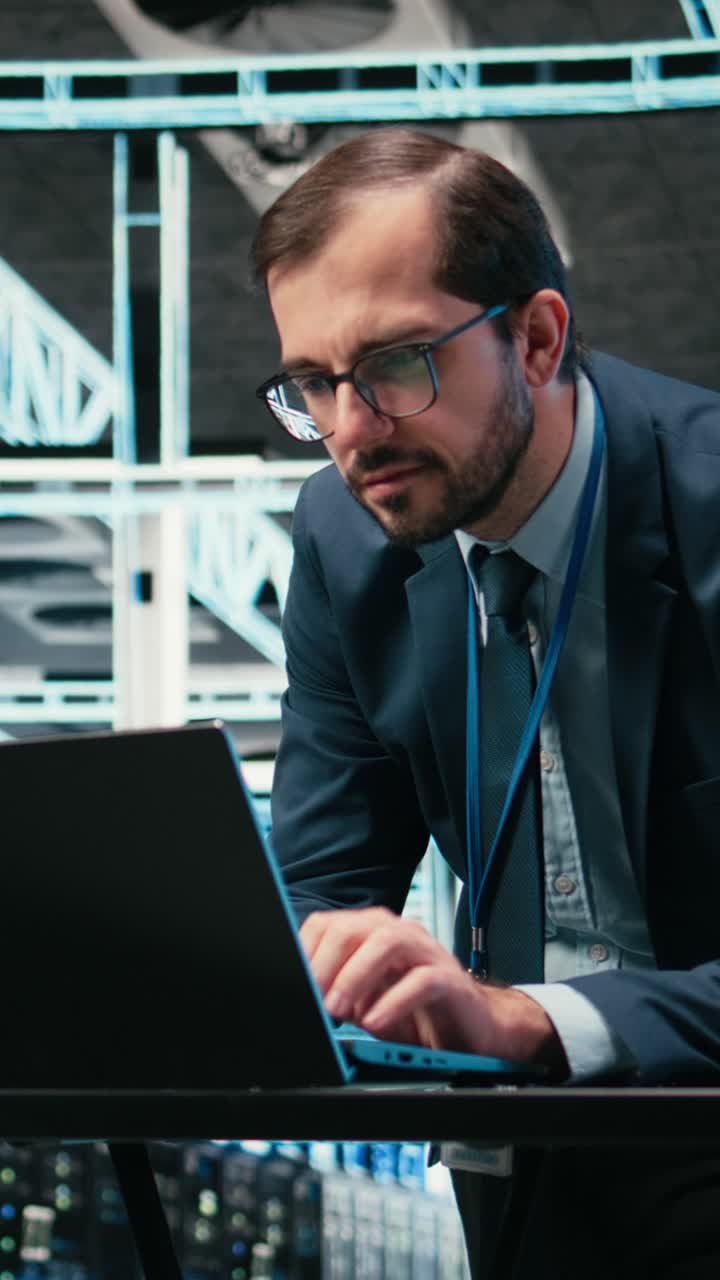 Vertical video Data center admin typing on laptop keyboard, doing resource optimization