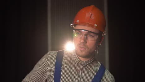 workman wears goggles and hard hat and gets to work