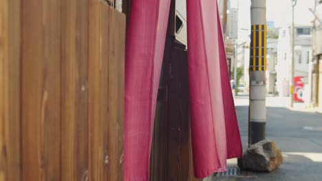 Slide-shot-of-curtain-blowing-in-the-wind-outside-a-restaurant-in-Kyoto,-Japan-4K-slow-motion