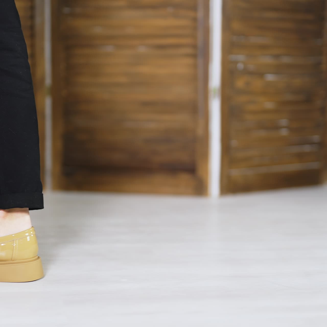 Beige lacquered shoes on plain soles demonstration. Model walks back and forth presenting new fashionable footwear. Blurred backdrop