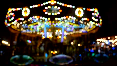 4k. abstract blur children's merry-go-round carousel at night with bokeh light on festival for background