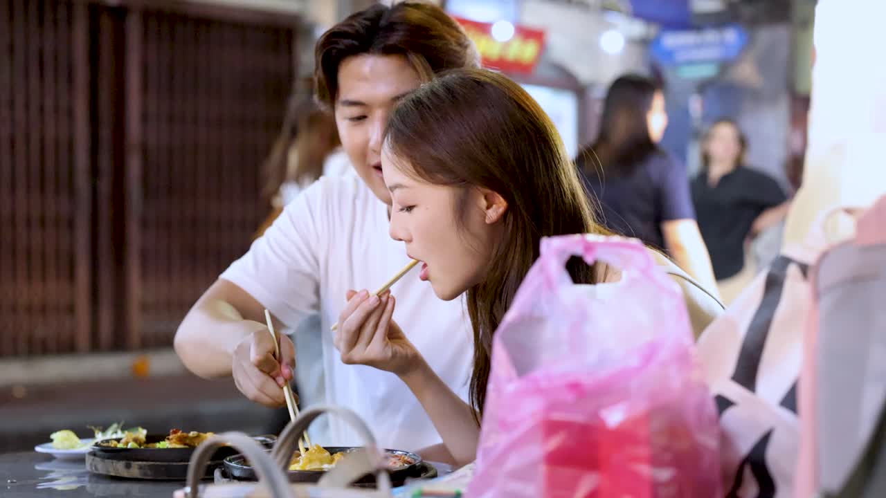 Couple enjoying street food at night