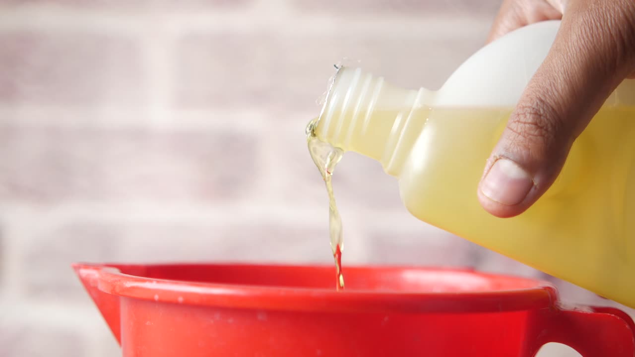 vertiendo aceite en una taza de medida roja