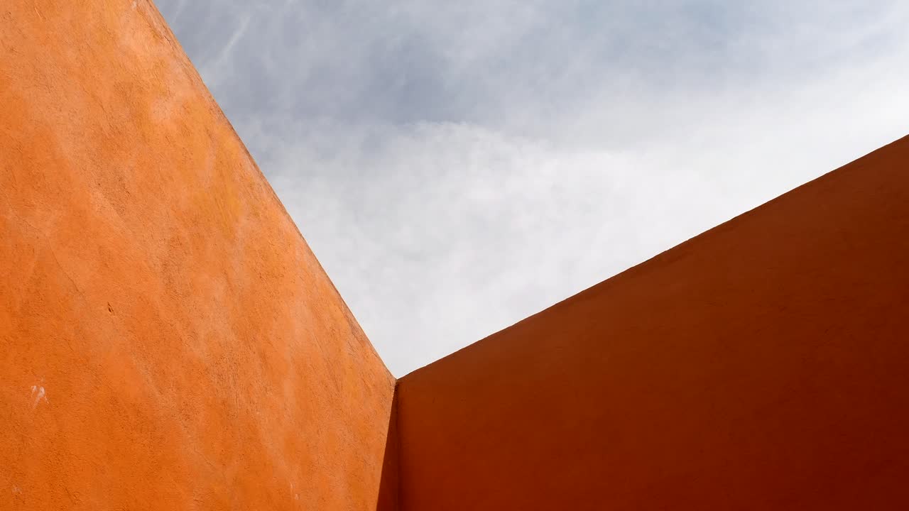 Orange Concrete Walls Against A Cloudy Sky Above -wide shot