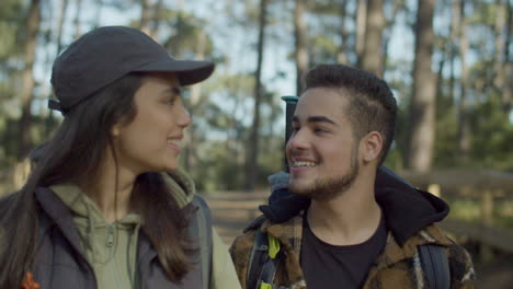 young couple walking in forest and kissing