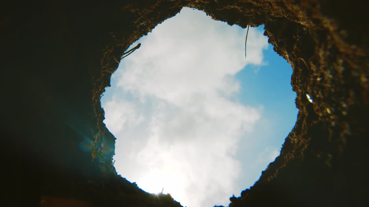 여름 동안 아름다운 푸른 하늘이 내려다보이는 땅에 있는 구멍, 시간 경과