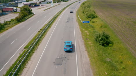 blue audi on a highway. luxury electric car driving slowly. presentation of e-tron automobile. aerial view.