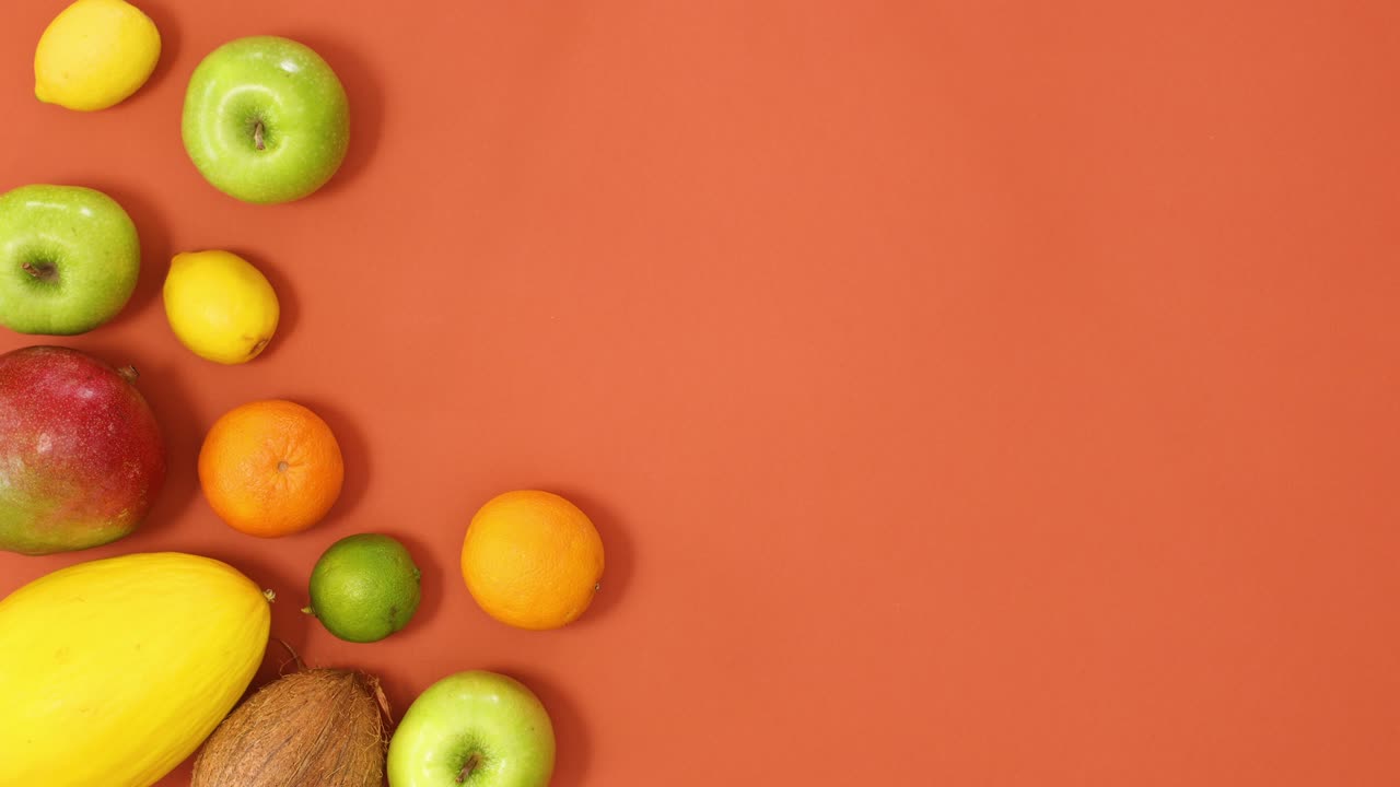 las frutas tropicales de verano se mueven en el lado izquierdo del fondo naranja. detenga el movimiento