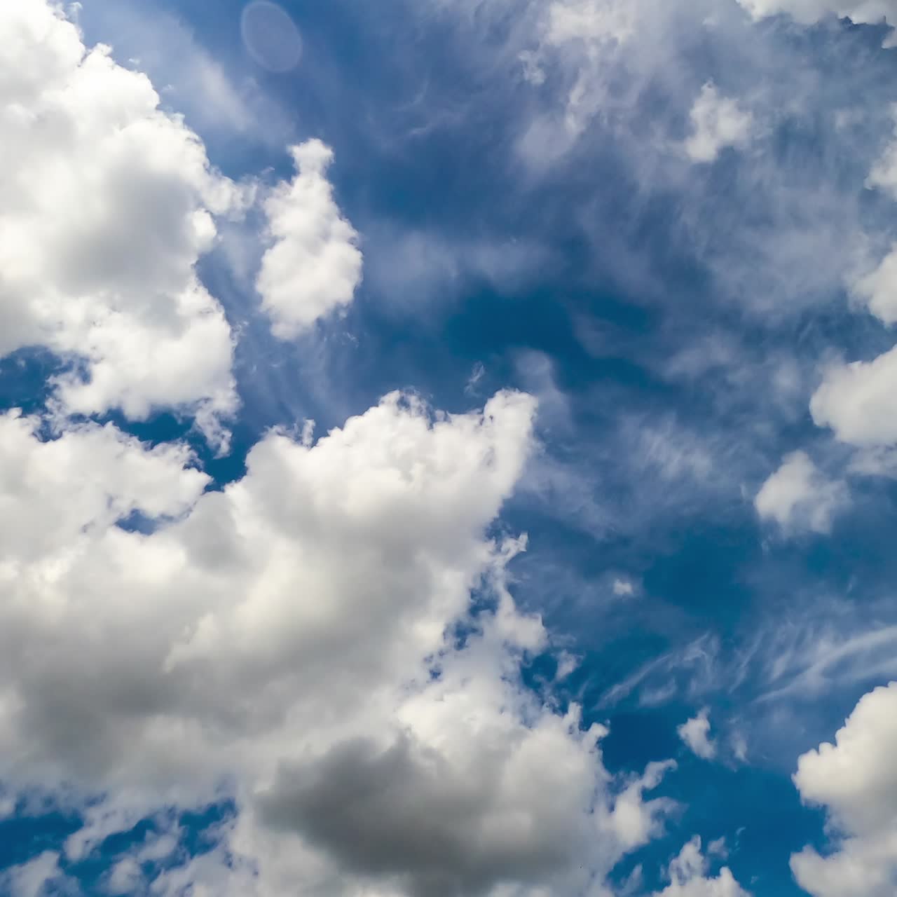 Light white clouds moving along the sky. Low angle view timelapse on sunny day