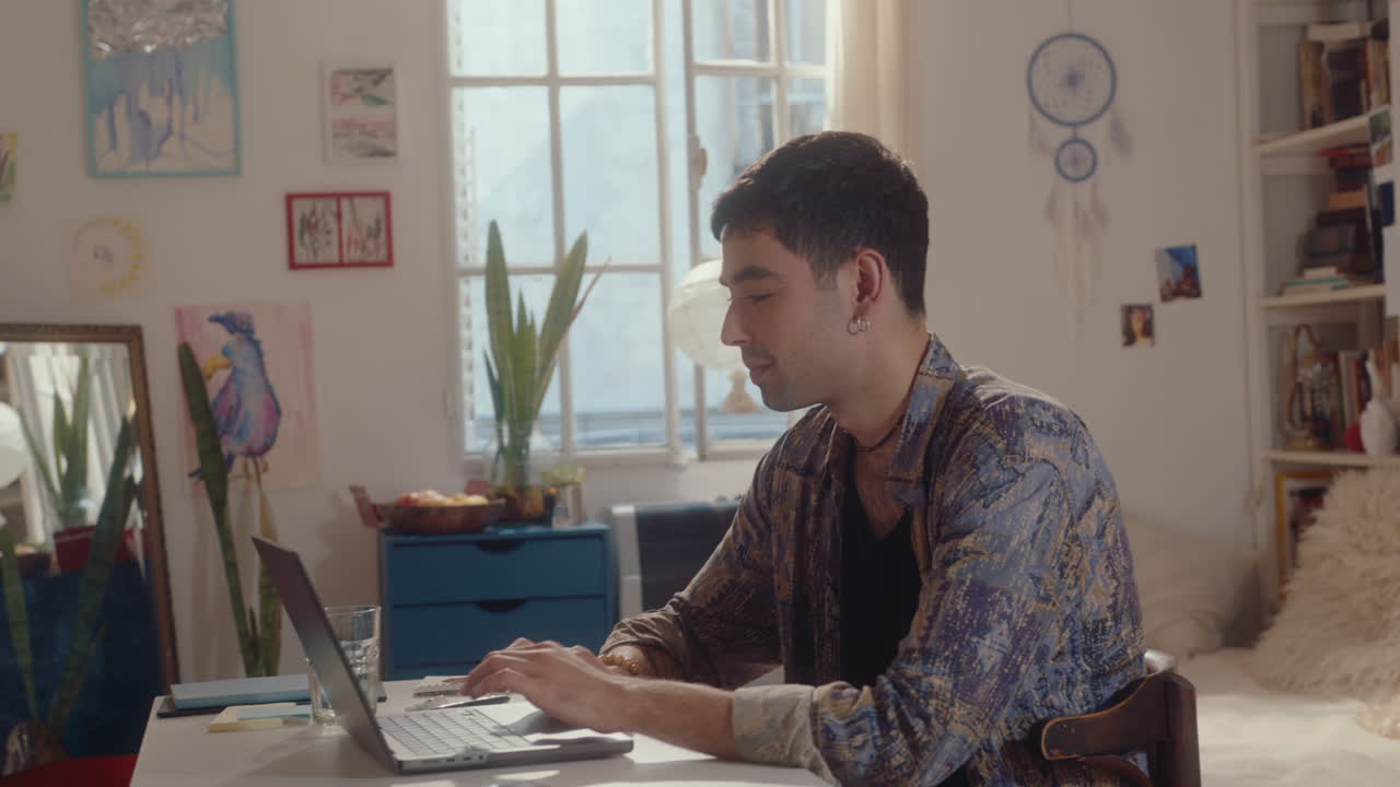 Young Man Typing on Laptop at Home