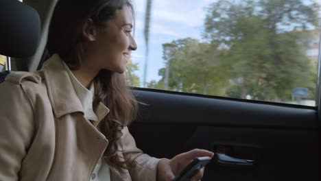 Female-Stylish-beautiful-Lady-Entrepreneur-in-taxi-uber-cab-car-talking-and-consulting-on-phone-business-going-to-work-in-a-traffic-jam