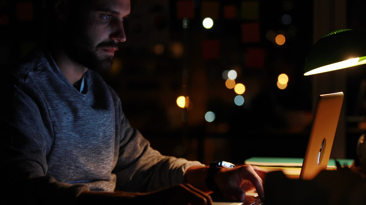 Casual businessman using laptop at night