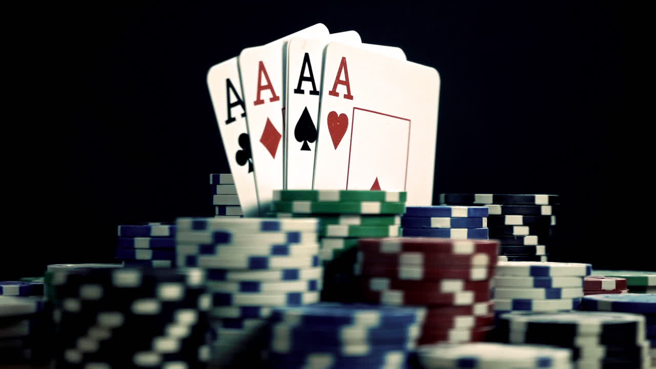Pokerchips och fyra ess spelkort på mörk bakgrund