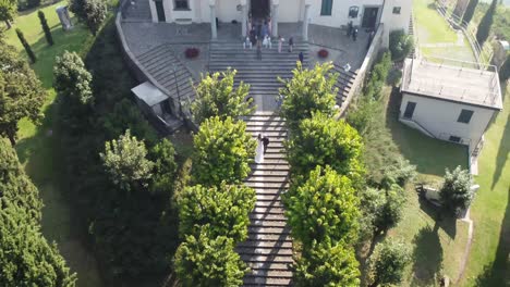 groom and bride walking up the stairs towards the beautiful church