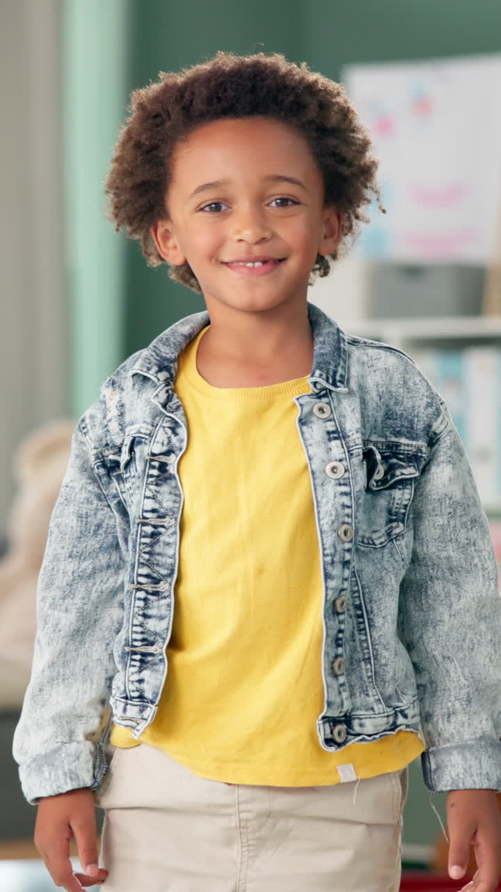 A smiling young boy in a denim jacket