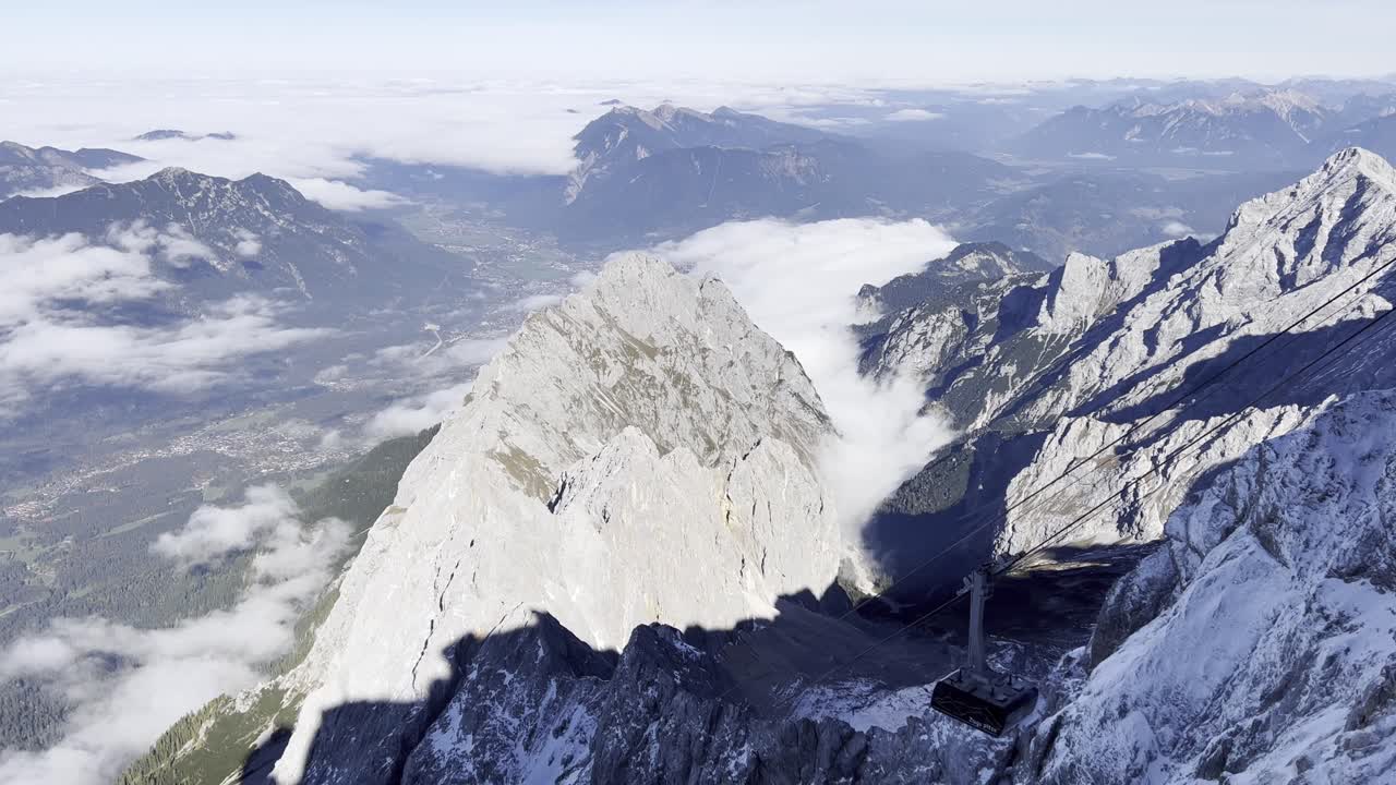 Scenic footage of a cable car descending from the summit station on Zugspitze, Germany's highest peak, passing the rocky alpine scenery of the Bavarian Alps in Southern Germany