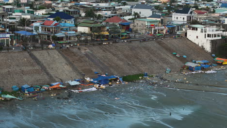 Pueblo-De-Pescadores-De-Mui-Ne-Bordeado-De-Desechos-Marinos-De-Plástico-En-La-Costa-Durante-La-Marea-Baja,-Teleobjetivo-Aéreo