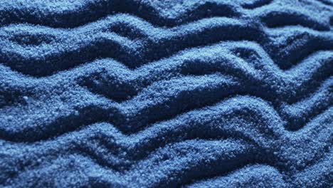 Video-of-close-up-of-blue-coloured-sand-with-pattern-and-copy-space-background