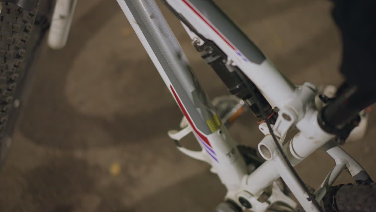 Focused Hand Motion, Tilted View Of Hand Positioning Neon Bottle With Streetlamp Reflections, Angled Shot Capturing Hand Inserting Neon Bottle Into Holder Amid Reflections And Linedup Tires