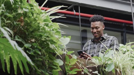 Happy-african-american-male-creative-using-smartphone-at-casual-office,-in-slow-motion