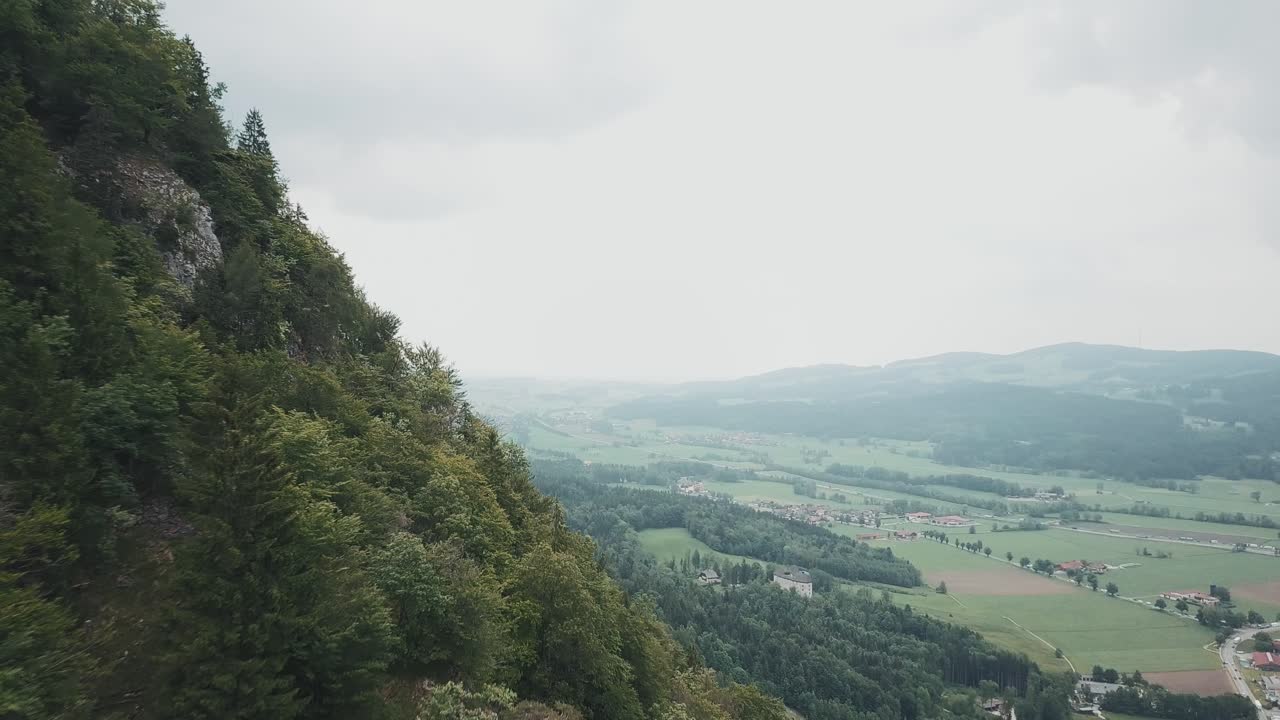 Droneoptagelse af en tysk skov og bjerge i Pidingerau, Oberbayern, Tyskland, på en skyet dag.