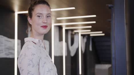 retrato de una feliz mujer de negocios caucásica en la oficina, cámara lenta