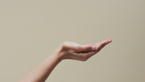 hands of asian woman on beige background with copy space, slow motion