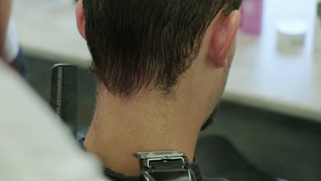 un hombre recortando el cabello en un barbero
