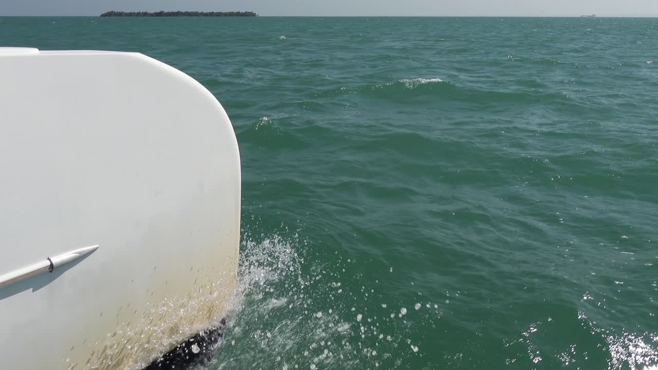 White catamaran hull and water splashing in 4K, static shot