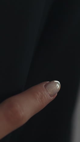 woman with white manicure strokes arm of beloved man wearing black jacket closeup. young couple in love relationship. happy wedding ceremony day