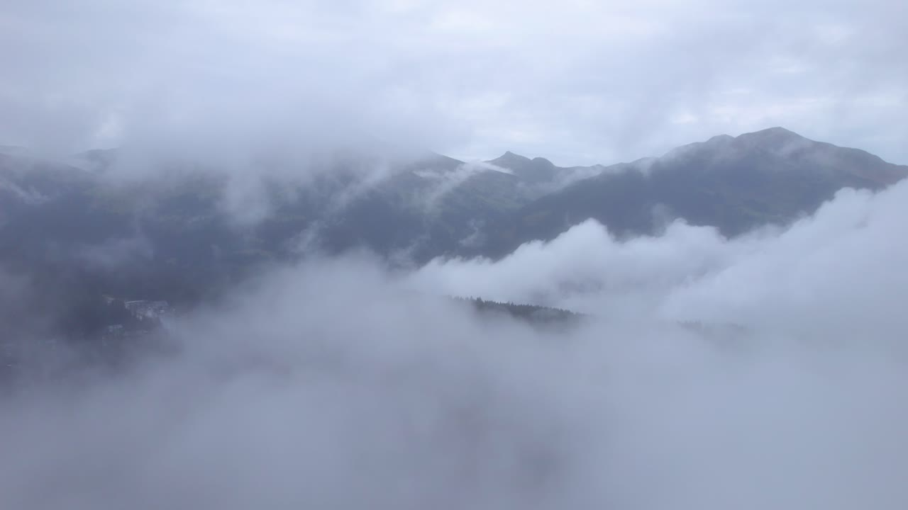 멀리서 산악 풍경을 발견하는 구름 사이를 비행하는 드론