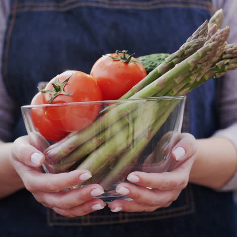 A-woman-holds-a-bowl-with-fresh-vegetables