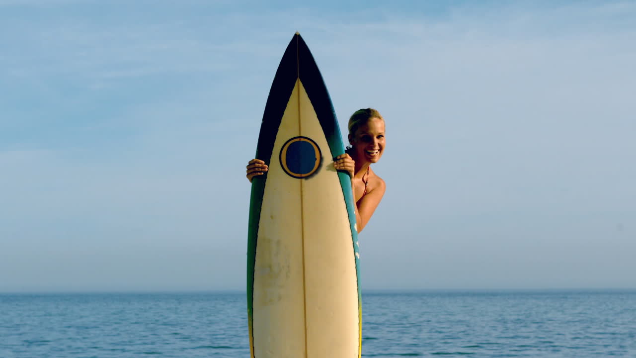 una mujer surfista mirando desde detrás de su tabla