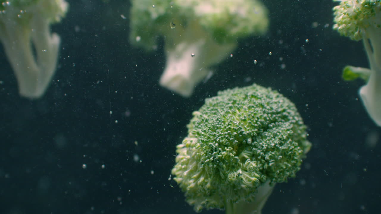 Green fresh broccoli washed in clear water before cooking slow motion